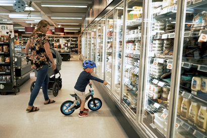 Mother with child in supermarket's cooling section