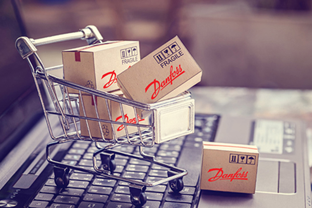 Dozen met Danfoss logo in mini boodschappenwagen op laptop toetsenbord