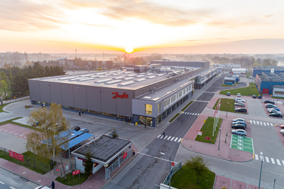 The factory seen from afar with a sunrise in the back