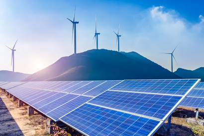 Solar panels and wind turbines in mountain landscape