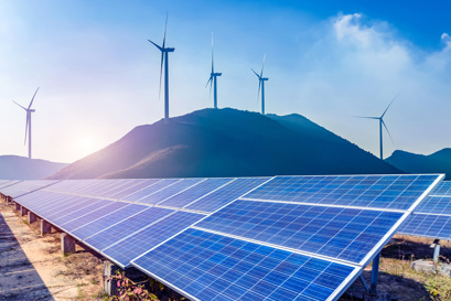 Solar panels and wind turbines in mountain landscape