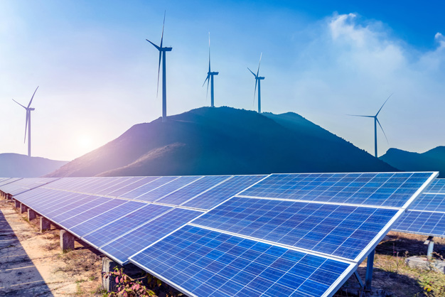 Solar panels and wind turbines in mountain landscape