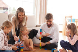 family playing with bricks on the floor