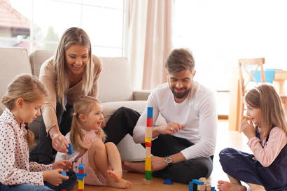 family playing with bricks on the floor