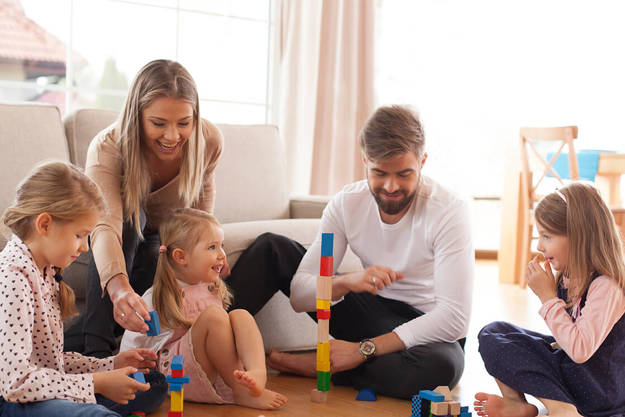 family playing with bricks on the floor
