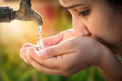 Woman drinking clean water from a spout