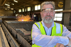 Man wearing protective glasses and hi-vis workwear looking towards the camera