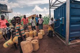 Residents in rural Kenya refilling drinking water from a station built by Solar Water Solutions and Danfoss
