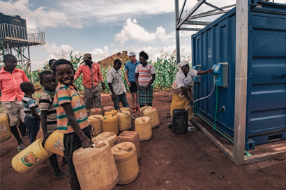Residents in rural Kenya refilling drinking water from a station built by Solar Water Solutions and Danfoss