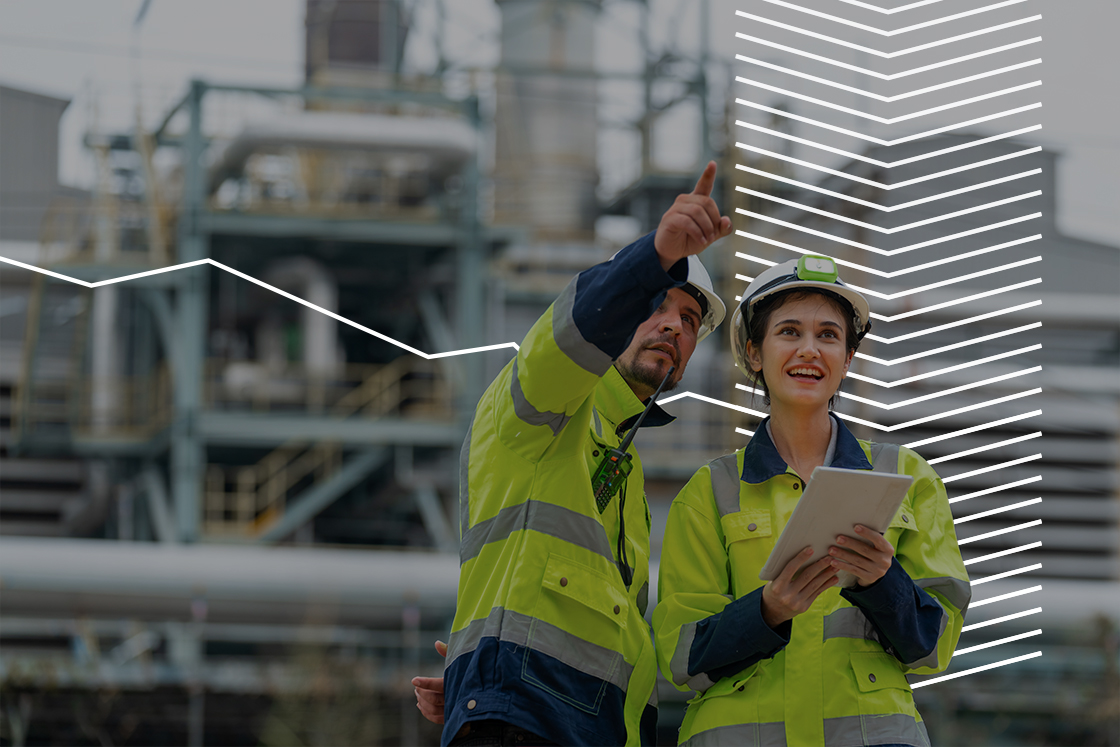 People in working clothes looking at industrial building