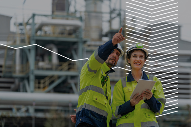 People in working clothes looking at industrial building