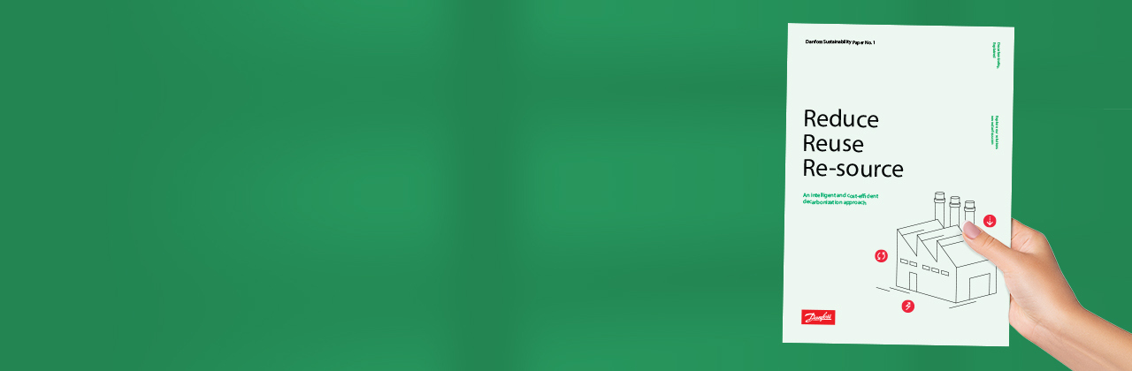 Image of a hand holding a Danfoss sustainability whitepaper with the heading: "Reduce, Reuse, Re-source"