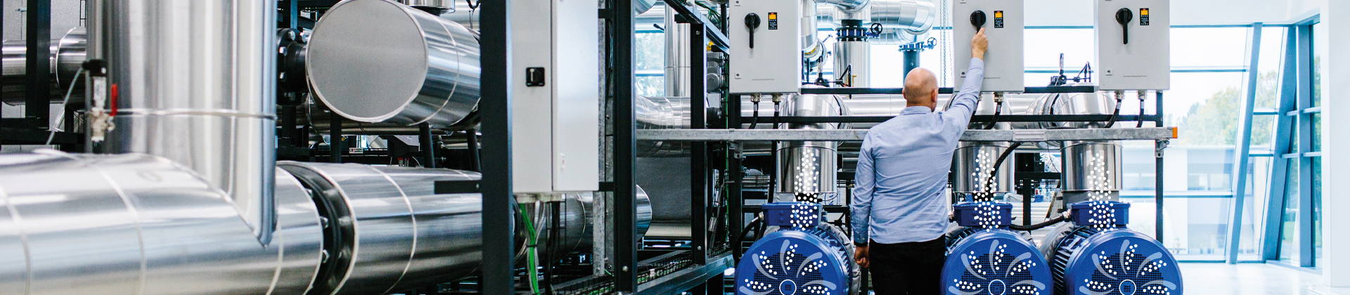 Mann beim Einstellen eines Hebels über mehreren Industriepumpen