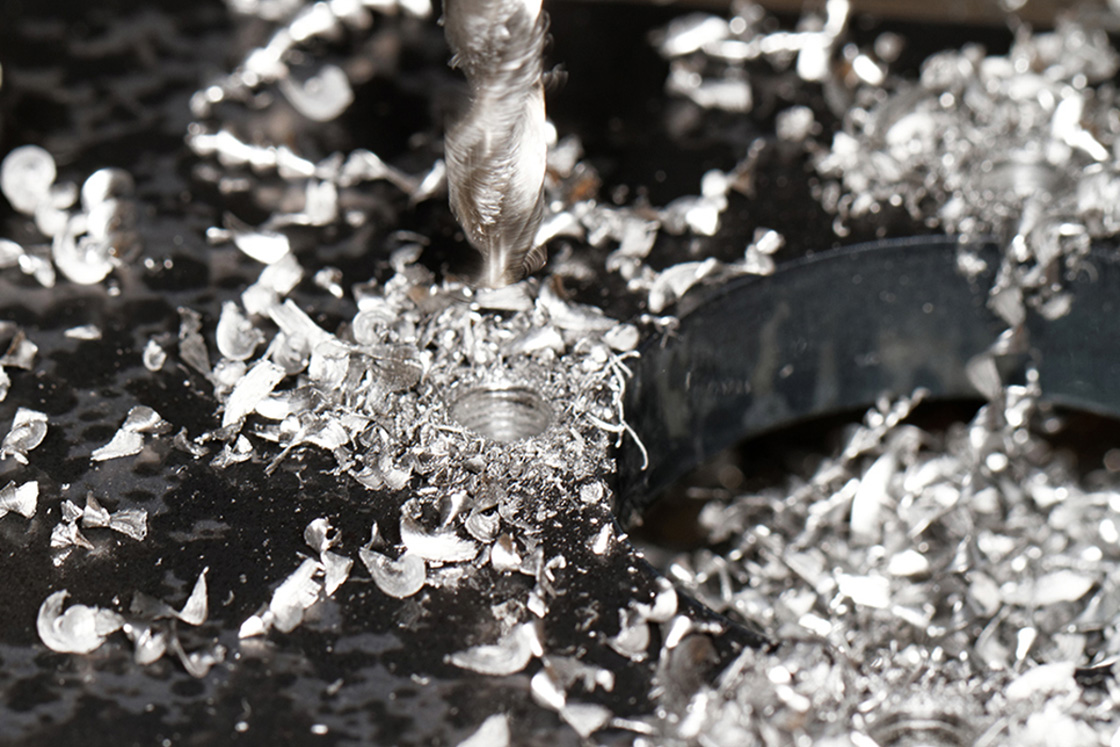 Tip of a drill surrounded by boron shavings 