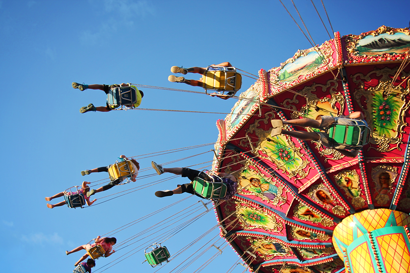 People in a high chair carousel at a market fair