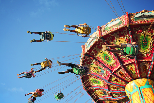 People in a high chair carousel at a market fair