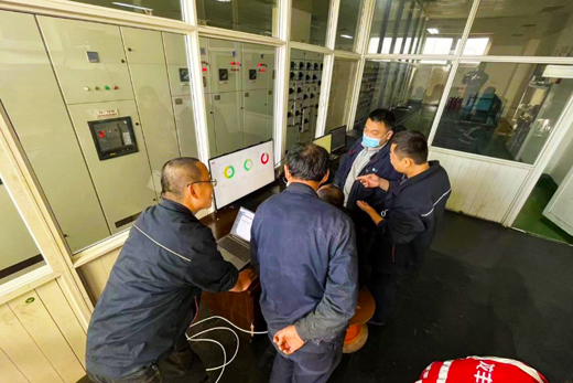 Engineers from Dahe Paper Group talking and looking at their custom dashboard built by Danfoss