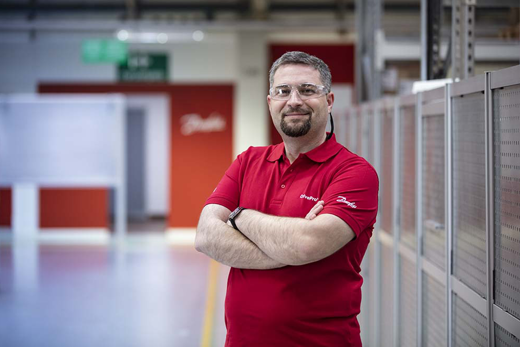 DrivePro Service man from Danfoss standing in front of a long row of drives