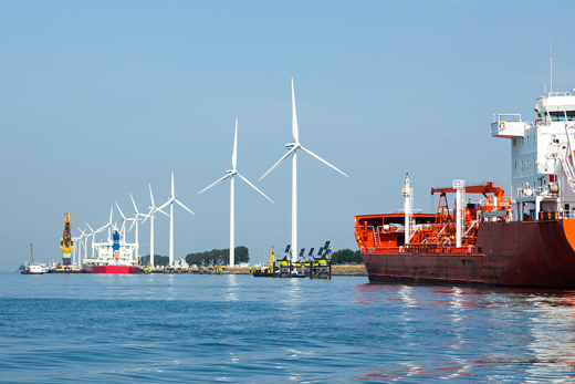 A row of wind turbines and various ships