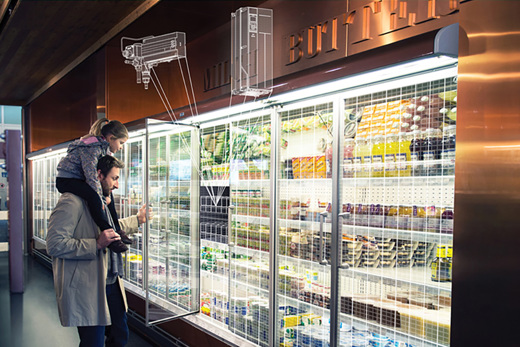 Man with his daughter on his shoulders, looking into a refrigeration case at a supermarket
