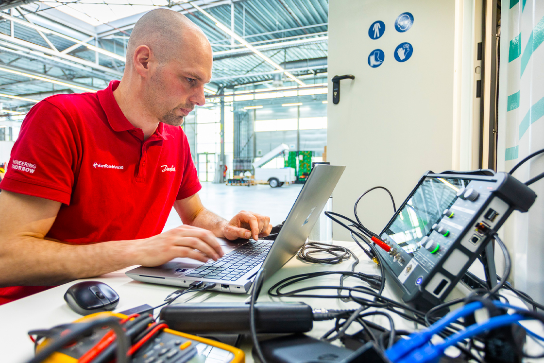 Danfoss Drives man looking at a computer connected to the system