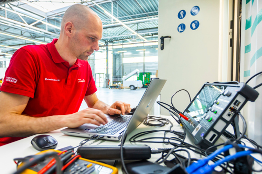 Danfoss Drives man looking at a computer connected to the system